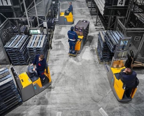 The Men on forklifts from Miami Industrial Trucks with pallets in warehouse.