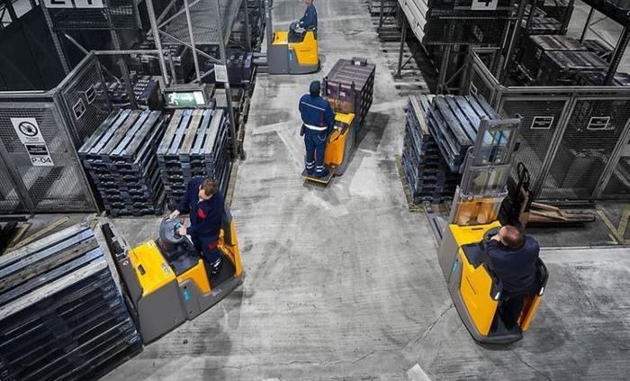 The Men on forklifts from Miami Industrial Trucks with pallets in warehouse.