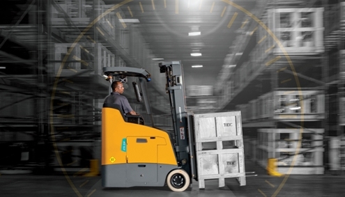 Forklift operator driving an electric stand-up counterbalanced lift truck