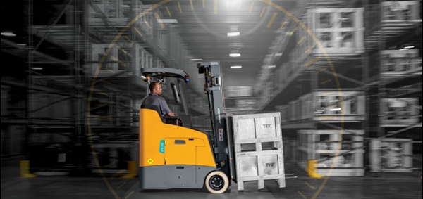 Forklift operator driving an electric stand-up counterbalanced lift truck