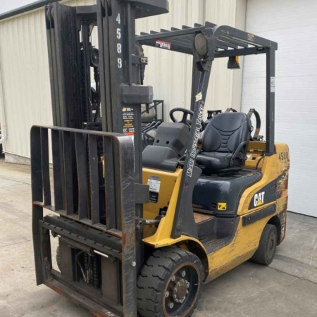 A CAT forklift without forks is parked outside a building in Dayton, OH.