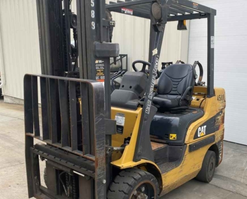 A CAT forklift without forks is parked outside a building in Dayton, OH.